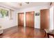 Bright bedroom featuring hardwood floors, two spacious closets, and a window offering natural light at 811 W Ocotillo Rd, Phoenix, AZ 85013