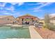 The backyard features a pool and large covered patio with an outdoor kitchen at 8420 W Cherry Hills Dr, Peoria, AZ 85345