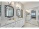 Elegant main bathroom features dual sinks with marble counters, framed mirrors, and glass shower at 8420 W Cherry Hills Dr, Peoria, AZ 85345