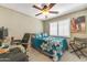 Cozy bedroom featuring a ceiling fan, white shutters, and a comfortable bed with a patterned comforter at 8420 W Cherry Hills Dr, Peoria, AZ 85345