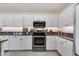 Modern kitchen showcases white cabinetry, granite countertops, and stainless steel appliances at 8420 W Cherry Hills Dr, Peoria, AZ 85345