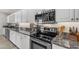 Bright kitchen features white cabinets, granite countertops, and stainless steel appliances at 8420 W Cherry Hills Dr, Peoria, AZ 85345