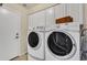 Functional laundry room with white cabinets and modern washer and dryer units at 8420 W Cherry Hills Dr, Peoria, AZ 85345