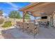 Covered outdoor kitchen with a built-in grill, bar seating, and dining area at 8420 W Cherry Hills Dr, Peoria, AZ 85345