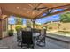 Inviting covered patio with a built-in BBQ area, outdoor seating, ceiling fan, and a view of the pool and yard at 8420 W Cherry Hills Dr, Peoria, AZ 85345