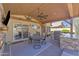 Covered patio featuring an outdoor kitchen, a dining area, and views of the backyard at 8420 W Cherry Hills Dr, Peoria, AZ 85345