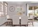 Bright dining room boasts a stylish table set, elegant clock, and sliding door to outdoor living space at 9733 E Axle Ave, Mesa, AZ 85212