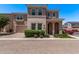 Two-story home with brick driveway, stucco and stone exterior, paired garage, and landscaped front yard at 9733 E Axle Ave, Mesa, AZ 85212