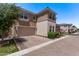Side angle view of the two-car garage of this house, complete with a brick driveway and lush front yard greenery at 9733 E Axle Ave, Mesa, AZ 85212