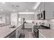 Bright kitchen with stainless steel appliances, large center island, and gray cabinets at 9733 E Axle Ave, Mesa, AZ 85212