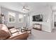 Comfortable living room featuring a ceiling fan, carpet flooring, and natural lighting at 9733 E Axle Ave, Mesa, AZ 85212
