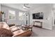Comfortable living room with a brown leather sofa, modern TV and a convenient residential elevator at 9733 E Axle Ave, Mesa, AZ 85212