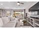 Spacious living room with wood-look flooring, ceiling fan, comfortable sofas, and access to an outdoor patio at 9733 E Axle Ave, Mesa, AZ 85212