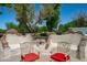 Landscaped backyard features a custom designed fireplace and seating area at 10532 W Catalina Dr, Avondale, AZ 85392
