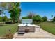 Modern hot tub in a well-maintained yard, with lush green grass and mature trees in the background at 10532 W Catalina Dr, Avondale, AZ 85392
