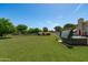 Expansive backyard features green grass, a hot tub, and a storage shed, offering space and functionality at 10532 W Catalina Dr, Avondale, AZ 85392