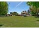 Scenic view of a large backyard with a hot tub, mature trees, and a covered patio at 10532 W Catalina Dr, Avondale, AZ 85392