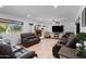 Living room with ceiling fan, fireplace, tile flooring, comfortable leather seating, and a view outside at 10532 W Catalina Dr, Avondale, AZ 85392