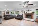 Spacious living room with tile flooring, fireplace, ceiling fan, and comfortable leather seating at 10532 W Catalina Dr, Avondale, AZ 85392