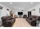 Inviting living room features tile flooring, a ceiling fan, a fireplace, and comfortable leather seating at 10532 W Catalina Dr, Avondale, AZ 85392