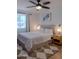 Comfortable bedroom with a ceiling fan, large window, and a cozy bed with a patterned area rug at 10609 N 32Nd Cir, Phoenix, AZ 85029