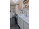 Well-lit laundry room boasts marble countertops, modern appliances, and ample storage space with black tile flooring at 10609 N 32Nd Cir, Phoenix, AZ 85029