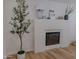 Cozy living room with a modern electric fireplace, light wood floors and a white textured surround at 10609 N 32Nd Cir, Phoenix, AZ 85029