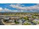 Wide aerial view of a residential neighborhood with tree-lined streets, many houses, a school, and partly cloudy skies at 11025 N 45Th Ln, Glendale, AZ 85304