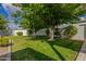 Serene backyard with lush green grass, mature shade trees, and beautiful landscaping at 11025 N 45Th Ln, Glendale, AZ 85304