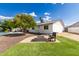 Landscaped backyard featuring a stone fire pit with built-in seating, synthetic grass, and fruit trees at 11025 N 45Th Ln, Glendale, AZ 85304