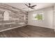 Spacious bedroom with decorative wall, fan, wood-look floors, and large window at 11025 N 45Th Ln, Glendale, AZ 85304