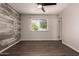 Bedroom featuring a decorative wall, wood-look floors, large window, and ceiling fan at 11025 N 45Th Ln, Glendale, AZ 85304
