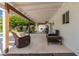 Inviting covered patio with travertine tile flooring, a comfortable seating area, and views of the backyard at 11025 N 45Th Ln, Glendale, AZ 85304