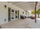 Covered patio featuring travertine flooring, modern lighting, and access to the yard and pool area at 11025 N 45Th Ln, Glendale, AZ 85304