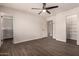 Large main bedroom featuring wood-look floors, ceiling fan, and direct access to the en-suite bathroom at 11025 N 45Th Ln, Glendale, AZ 85304