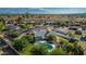 Aerial view of home featuring a private pool, covered patio, grassy yard, mature trees, and an outdoor lounge area at 11025 N 45Th Ln, Glendale, AZ 85304