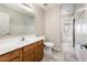 Bathroom features tiled floors, wood-trimmed sink, and a toilet with views to the hallway at 1144 E Elm Rd, San Tan Valley, AZ 85140