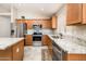 Well-lit kitchen featuring stainless steel appliances, granite countertops, and wood cabinets at 1144 E Elm Rd, San Tan Valley, AZ 85140