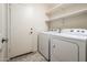 Bright laundry area features a full size washer and dryer, overhead storage shelving and convenient access to the exterior at 1144 E Elm Rd, San Tan Valley, AZ 85140