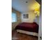 This cozy bedroom is well-lit with a calming ambiance, with a maroon comforter at 12123 W Bell Rd # 337, Surprise, AZ 85378