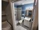 Modern bathroom with gray tile walk-in shower, toilet, and vanity next to washer/dryer at 125 S 56Th St # 75, Mesa, AZ 85206