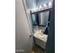 Stylish half-bathroom with a sleek vanity, a mirror with vanity lighting, and modern fixtures at 125 S 56Th St # 75, Mesa, AZ 85206