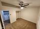 Bedroom featuring ceiling fan, neutral paint, carpet, and a view of the laundry room at 125 S 56Th St # 75, Mesa, AZ 85206