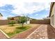 Backyard with a path, mature landscaping, grass and a white storage building at 14205 N 136Th Ln, Surprise, AZ 85379