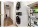 Convenient laundry area with stacked washer and dryer, plus organized shelving and storage space at 14205 N 136Th Ln, Surprise, AZ 85379