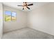 Bedroom with neutral walls, ceiling fan, carpet, and a view of the exterior at 14916 W Georgia Dr, Surprise, AZ 85379
