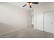 Neutral bedroom features a ceiling fan, plush carpet and large closet at 14916 W Georgia Dr, Surprise, AZ 85379