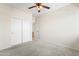 Bedroom features a ceiling fan, carpet and a closet with sliding doors at 14916 W Georgia Dr, Surprise, AZ 85379