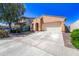 Single-Gathering home with a two-car garage, light stucco and landscaped front yard with mature trees on a sunny day at 14916 W Georgia Dr, Surprise, AZ 85379