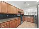 Traditional kitchen with wood cabinets, granite countertops, stainless steel appliances, and an open layout at 14916 W Georgia Dr, Surprise, AZ 85379